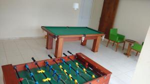 mesa de ping pong en una habitación con mesa de billar en Apto em Cabo Frio com conforto e qualidade., en Cabo Frío