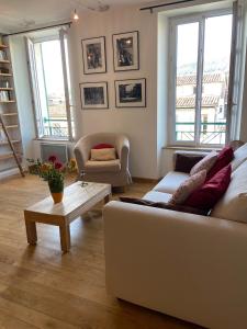 uma sala de estar com um sofá branco e uma mesa de centro em Calme et confort en coeur de ville em Draguignan