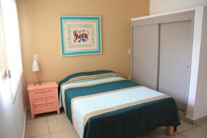 a small bedroom with a bed and a night stand at Amapas Apartments Puerto Vallarta in Puerto Vallarta