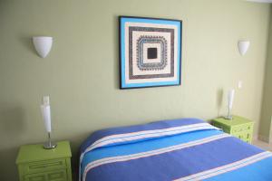 a bedroom with a bed and a picture on the wall at Amapas Apartments Puerto Vallarta in Puerto Vallarta