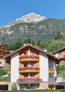 ein Gebäude mit Blumen und einem Berg im Hintergrund in der Unterkunft Al Truciolo in Andalo