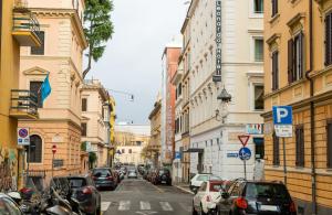 uma movimentada rua da cidade com carros estacionados na rua em Leonardo Boutique Hotel Rome Termini em Roma