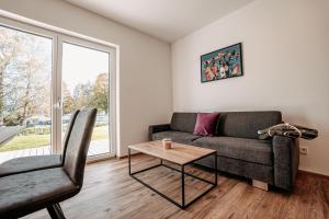 ein Wohnzimmer mit einem Sofa und einem Tisch in der Unterkunft Tanners Chalet Apartments in Altenmarkt im Pongau