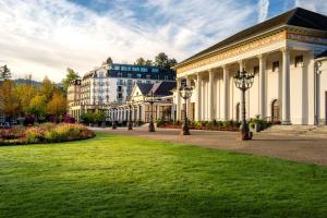 een gebouw met een groen gazon voor een gebouw bij Maison Messmer - ein Mitglied der Hommage Luxury Hotels Collection in Baden-Baden