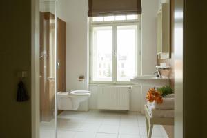 a bathroom with a toilet and a sink and a window at Hotel Kašperk in Kašperské Hory