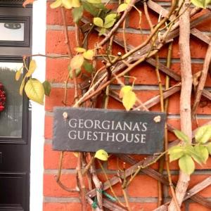 un panneau sur le côté d'un bâtiment en briques dans l'établissement Georgiana's Guesthouse, à Londres