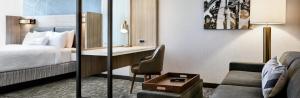 SpringHill Suites by Marriott Detroit Dearborn في ديربورن: غرفة الفندق بسرير ومكتب واريكة