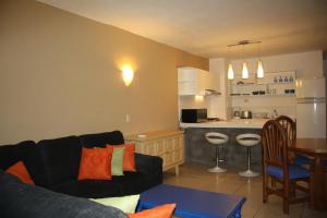 a living room with a couch and a kitchen at Amapas Apartments Puerto Vallarta in Puerto Vallarta