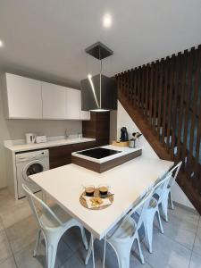 een keuken met een witte tafel en een aantal stoelen bij Chez Emma et Louise - Maison individuelle avec stationnement gratuit in Mâcon