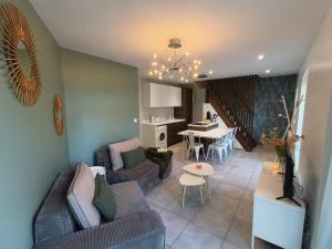 een woonkamer met een bank en een tafel bij Chez Emma et Louise - Maison individuelle avec stationnement gratuit in Mâcon