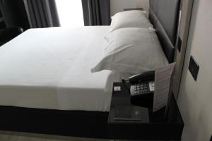 een hotelkamer met een bed en een telefoon op een tafel bij LHP Hotel Napoleon in Milaan