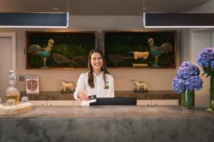 een vrouw staat aan een balie in een salon bij The Lince Nordeste in Nordeste