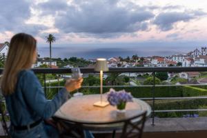 een vrouw die een foto neemt van het uitzicht vanaf haar balkon bij The Lince Nordeste in Nordeste