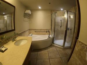 a bathroom with a tub and a sink and a shower at Costa Bahia Hotel Paseo Caribe in San Juan