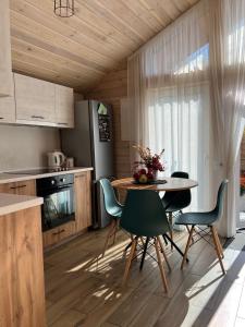 - une cuisine et une salle à manger avec une table et des chaises dans l'établissement Treeskit House, à Horenka