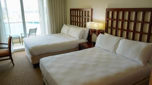 a hotel room with two beds and a window at Costa Bahia Hotel Paseo Caribe in San Juan