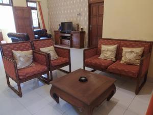 uma sala de estar com cadeiras e uma mesa de centro em Ma Maison Guest House em Yogyakarta