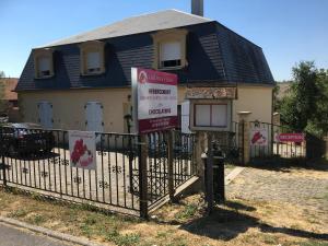 une maison avec des panneaux devant une clôture dans l'établissement Orchidee Rose, à Givet