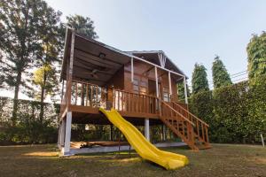 a tiny house with a slide and a play structure at StayVista at The Banyan Abode with Pool Table, Pet Friendly & Outdoor Pool in Manesar