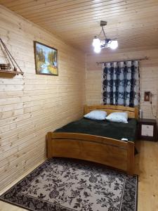 1 dormitorio con 1 cama en una habitación de madera en Котедж "Затишний відпочинок", en Huklyvyy