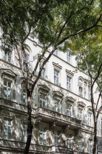 a large white building with trees in front of it at Pension Primavera in Vienna