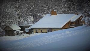 dom pokryty śniegiem obok stosu śniegu w obiekcie Auberge De La Poulcière w mieście Gérardmer