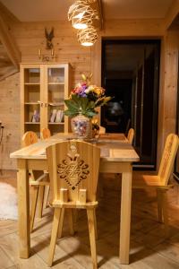 uma mesa de jantar em madeira com um vaso de flores em Domek Zakopiański Czar em Zakopane