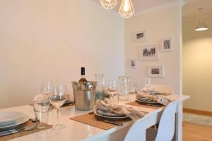 uma sala de jantar com uma mesa com copos de vinho em Machico Beach, a Home in Madeira em Machico