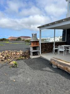 um pátio com um fogão, uma mesa e cadeiras em El Cercado em Tinajo