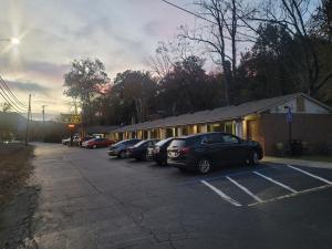 un groupe de voitures garées sur un parking dans l'établissement Economy Inn Sylva, à Sylva