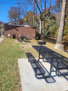 une table de pique-nique et des bancs dans un parc dans l'établissement Economy Inn Sylva, à Sylva