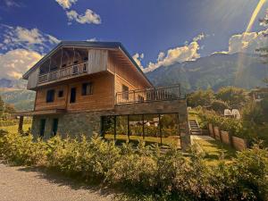 ein Holzhaus mit Balkon auf einem Hügel in der Unterkunft Chalet Amour blanc in Les Houches