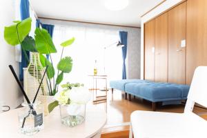 a living room with a table and a blue couch at Yokkaichi Motomachi Hotel in Yokkaichi