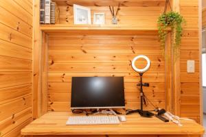 a desk with a computer on a wooden wall at Yokkaichi Motomachi Hotel in Yokkaichi