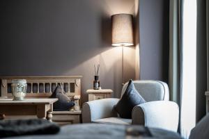 - un salon avec deux chaises, une table et une lampe dans l'établissement Hotel Acadia - Adults Mountain Home, à Selva di Val Gardena