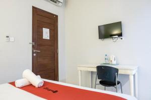 Zimmer mit einem Bett, einem Schreibtisch und einem TV in der Unterkunft RedDoorz Plus at Sunrise Hotel Sanur in Sanur