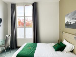 - une chambre avec un lit, une fenêtre et une chaise dans l'établissement Colette Hôtel, à Niort