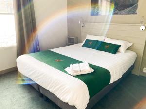 - une chambre avec un grand lit et des serviettes dans l'établissement Colette Hôtel, à Niort