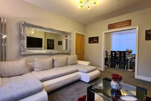 a living room with a couch and a mirror at Stunning Holiday Home. Free Parking. in Manchester