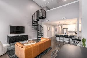 un soggiorno con divano e una scala a chiocciola di Soaring 2-Bedroom Parkside Loft Walkable to it All a Cincinnati