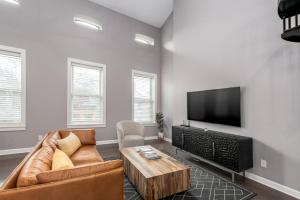 un soggiorno con divano e TV a schermo piatto di Soaring 2-Bedroom Parkside Loft Walkable to it All a Cincinnati