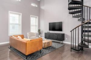 un soggiorno con divano e TV di Soaring 2-Bedroom Parkside Loft Walkable to it All a Cincinnati