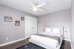 una camera bianca con letto e ventilatore a soffitto di Soaring 2-Bedroom Parkside Loft Walkable to it All a Cincinnati