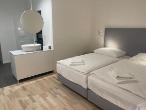 um quarto com 2 camas, um lavatório e um espelho em Hotel Praha Liberec em Liberec