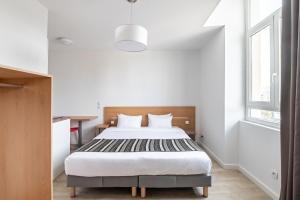 1 dormitorio con cama y ventana en Residhotel Le Central'Gare, en Grenoble