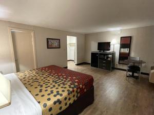 a hotel room with a bed and a flat screen tv at Economy Inn in East Hartford