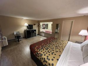 a hotel room with a large bed and a desk at Economy Inn in East Hartford