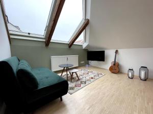 Sala de estar con sofá, mesa y guitarra en Helles Apartment im Zentrum, en Graz