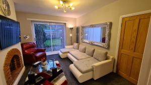 a living room with a couch and a fireplace at Stunning Holiday Home. Free Parking. in Manchester