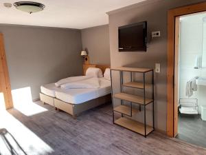 1 dormitorio con 1 cama y TV en la pared en Schwaiger, en Breitenbach am Inn